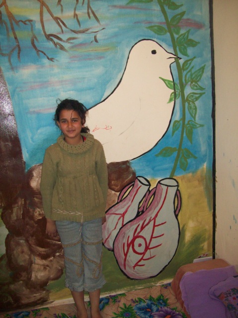 J and L's oldest daughter R, with the peace mural on their farmhouse wall